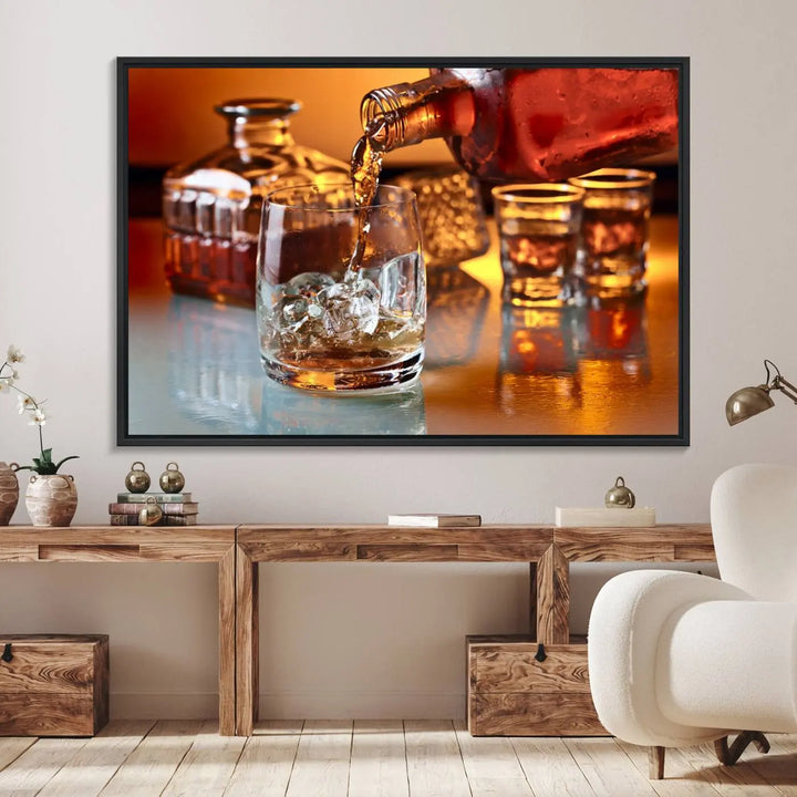 The Elegant Whiskey Canvas Art captures the reflection of a whiskey bottle pouring into an iced glass beside two filled ones.