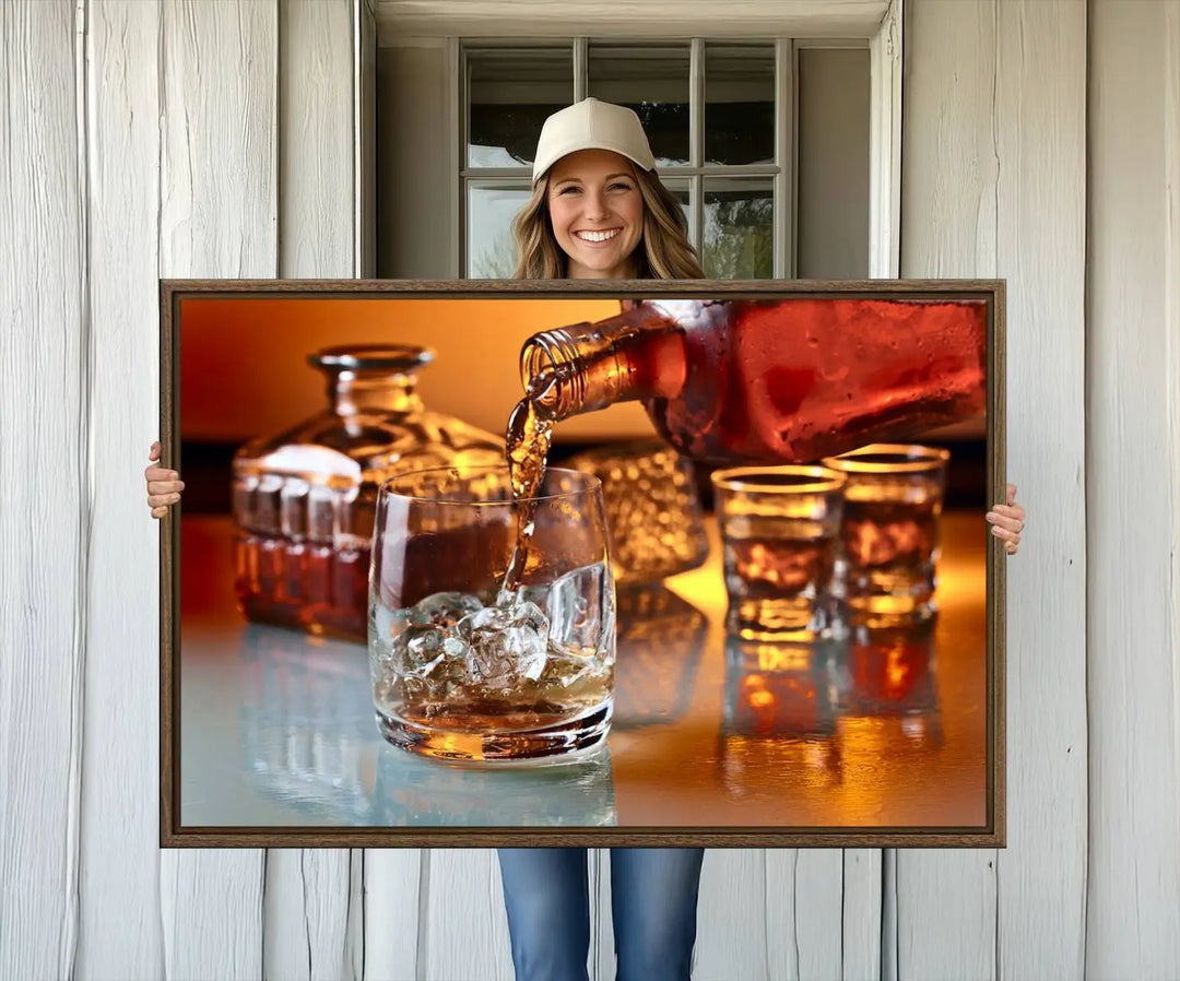 The Elegant Whiskey Canvas Art captures the reflection of a whiskey bottle pouring into an iced glass beside two filled ones.