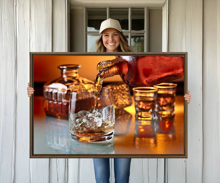 The Elegant Whiskey Canvas Art captures the reflection of a whiskey bottle pouring into an iced glass beside two filled ones.