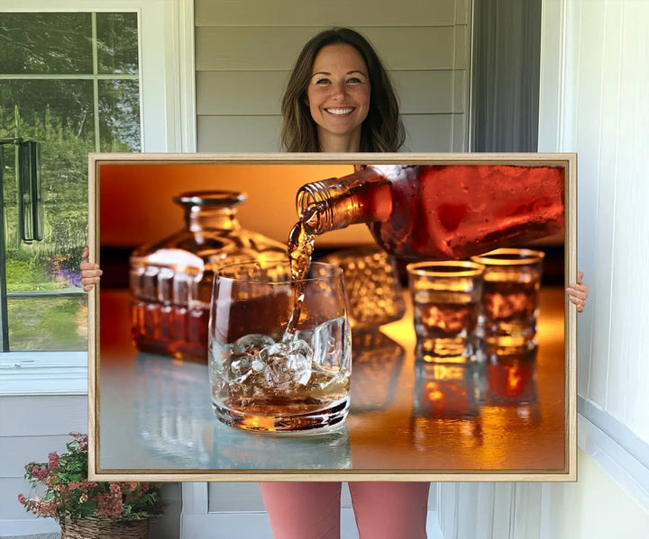 The Elegant Whiskey Canvas Art captures the reflection of a whiskey bottle pouring into an iced glass beside two filled ones.