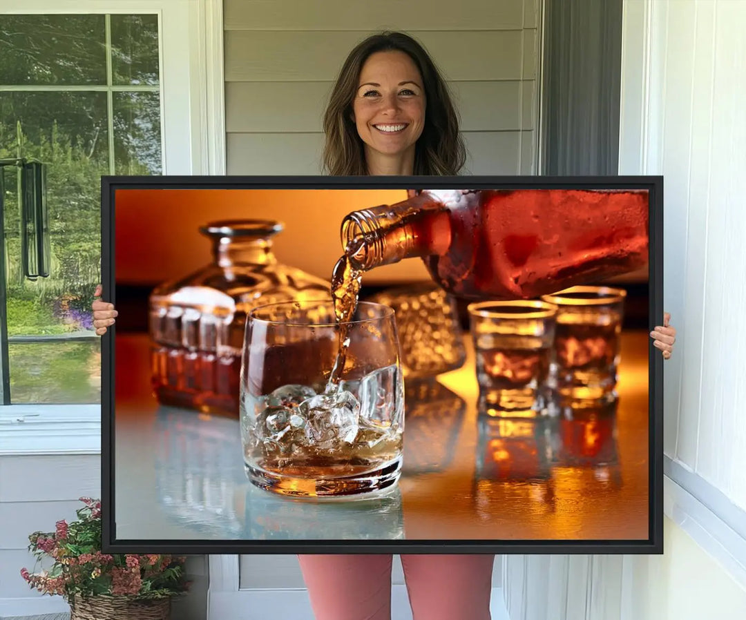 The Elegant Whiskey Canvas Art captures the reflection of a whiskey bottle pouring into an iced glass beside two filled ones.