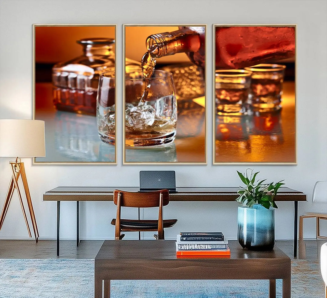 The Elegant Whiskey Canvas Art captures the reflection of a whiskey bottle pouring into an iced glass beside two filled ones.