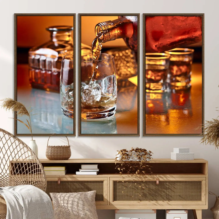 The Elegant Whiskey Canvas Art captures the reflection of a whiskey bottle pouring into an iced glass beside two filled ones.