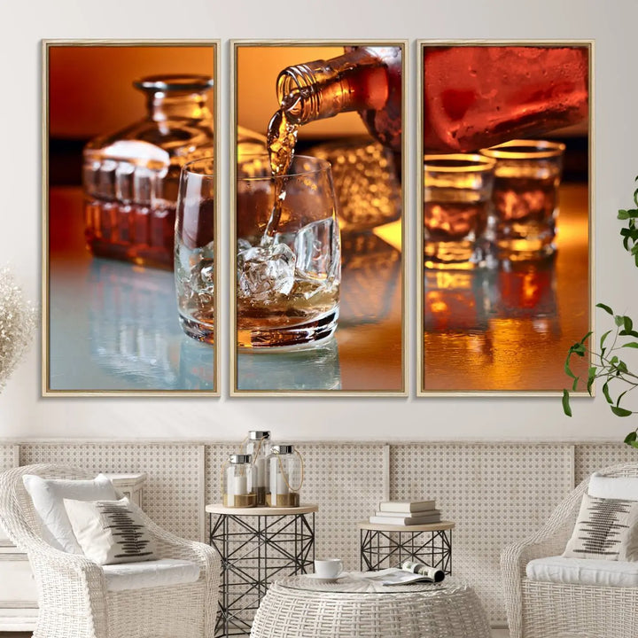 The Elegant Whiskey Canvas Art captures the reflection of a whiskey bottle pouring into an iced glass beside two filled ones.