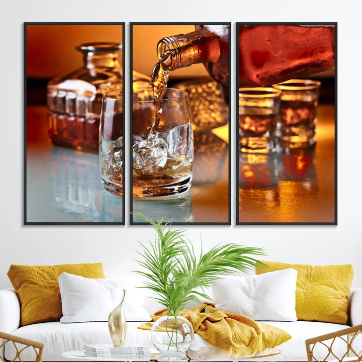 The Elegant Whiskey Canvas Art captures the reflection of a whiskey bottle pouring into an iced glass beside two filled ones.