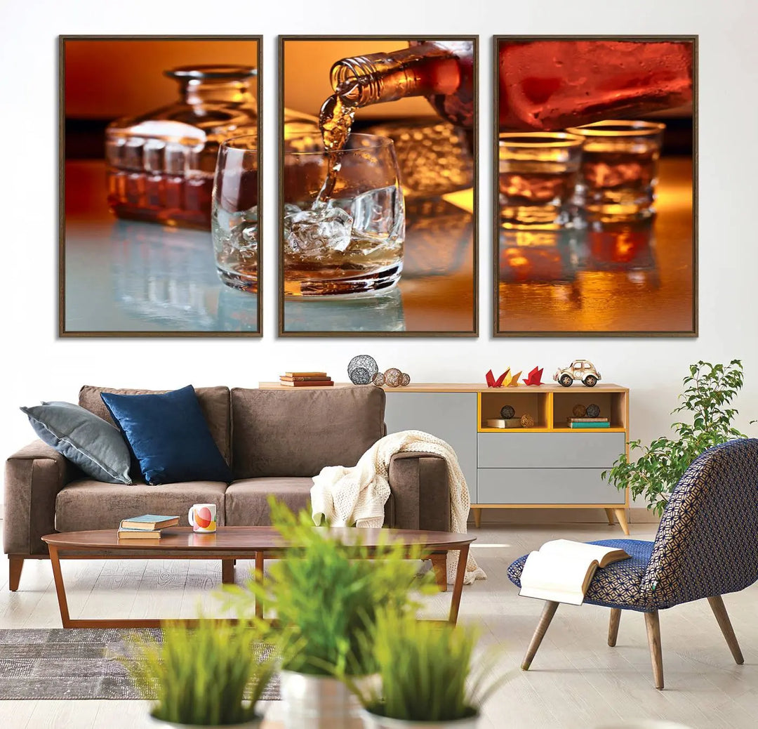 The Elegant Whiskey Canvas Art captures the reflection of a whiskey bottle pouring into an iced glass beside two filled ones.