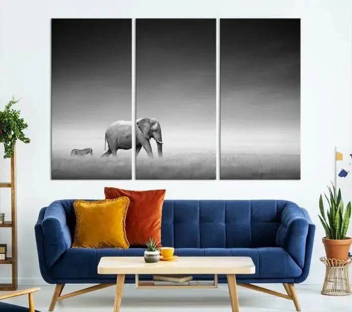 Elephant and Zebra Wall Art Canvas Print: A black and white triptych on museum-quality canvas, showcasing an elephant and zebra walking across a grassy plain. Equipped with a UV-protective coating for lasting protection.