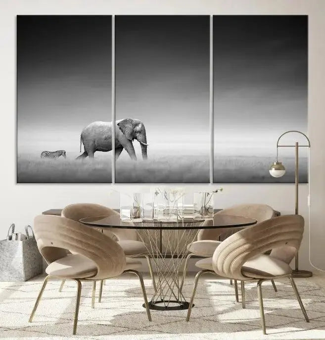 Elephant and Zebra Wall Art Canvas Print: A black and white triptych on museum-quality canvas, showcasing an elephant and zebra walking across a grassy plain. Equipped with a UV-protective coating for lasting protection.