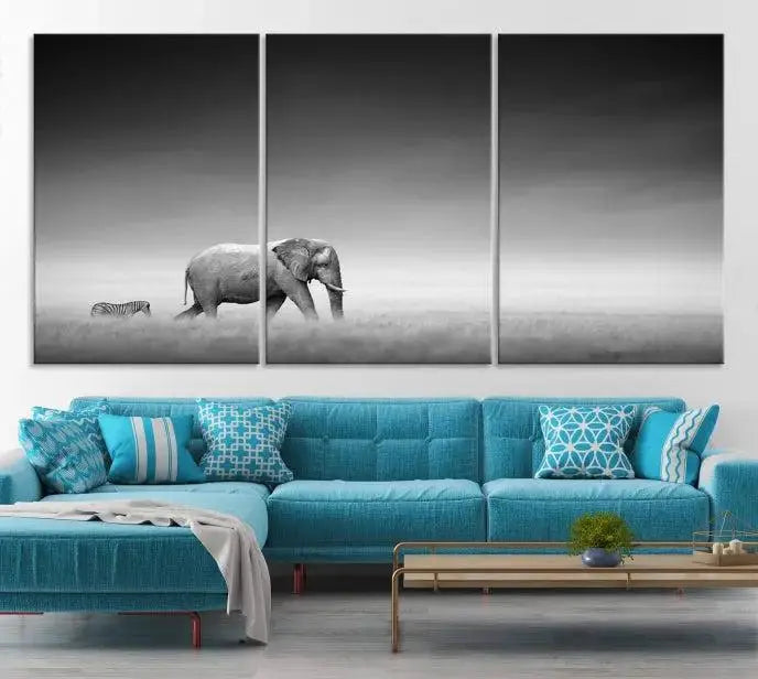 Elephant and Zebra Wall Art Canvas Print: A black and white triptych on museum-quality canvas, showcasing an elephant and zebra walking across a grassy plain. Equipped with a UV-protective coating for lasting protection.