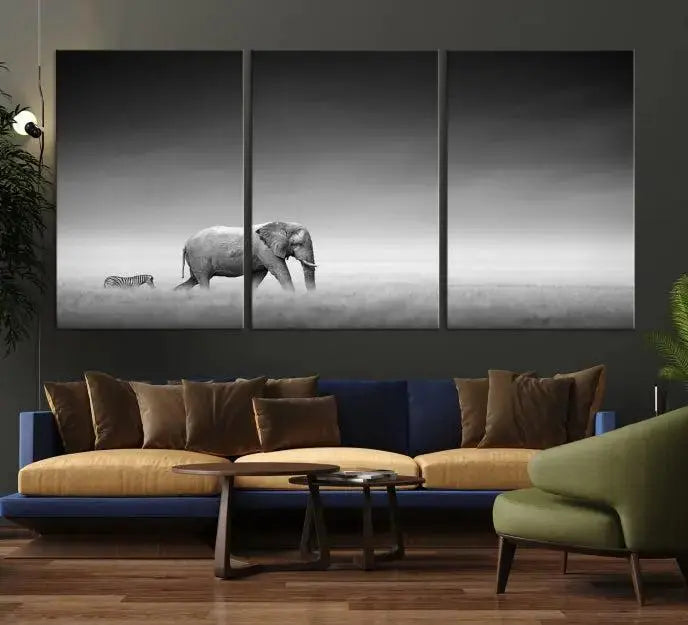 Elephant and Zebra Wall Art Canvas Print: A black and white triptych on museum-quality canvas, showcasing an elephant and zebra walking across a grassy plain. Equipped with a UV-protective coating for lasting protection.