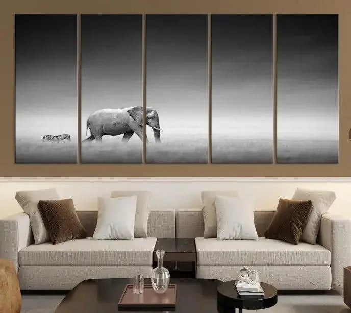 Elephant and Zebra Wall Art Canvas Print: A black and white triptych on museum-quality canvas, showcasing an elephant and zebra walking across a grassy plain. Equipped with a UV-protective coating for lasting protection.