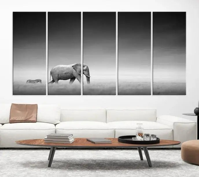 Elephant and Zebra Wall Art Canvas Print: A black and white triptych on museum-quality canvas, showcasing an elephant and zebra walking across a grassy plain. Equipped with a UV-protective coating for lasting protection.