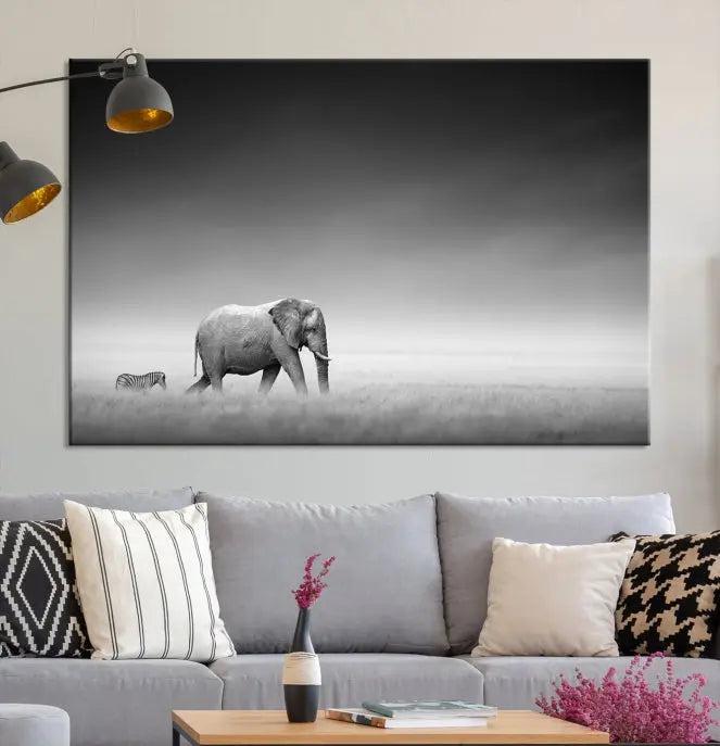 Elephant and Zebra Wall Art Canvas Print: A black and white triptych on museum-quality canvas, showcasing an elephant and zebra walking across a grassy plain. Equipped with a UV-protective coating for lasting protection.