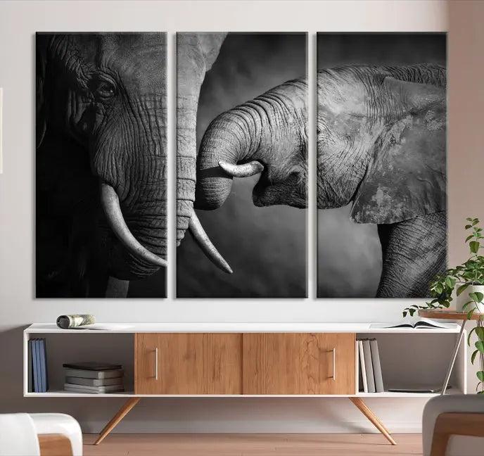 The "Elephant Family Wall Art Canvas Print" is a black-and-white triptych depicting elephants touching trunks, crafted on museum-quality canvas with a UV-protective coating. This ready-to-hang piece adds an elegant touch to any room.