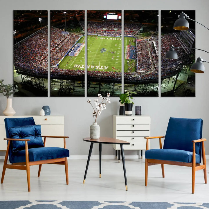 The wall art is a triptych canvas depicting the Florida Atlantic University Owls Football Team at the Boca Raton FAU Stadium, offering a gallery-quality finish.