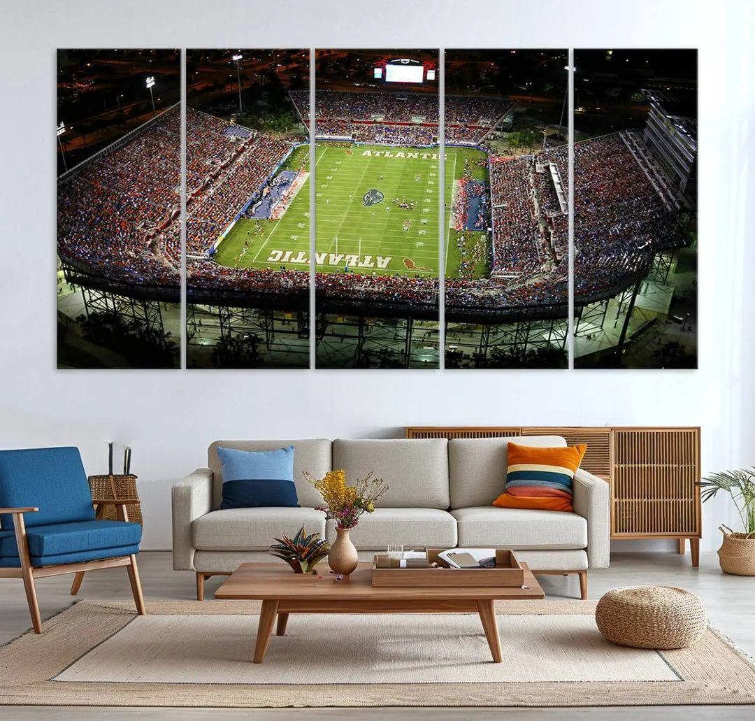 The wall art is a triptych canvas depicting the Florida Atlantic University Owls Football Team at the Boca Raton FAU Stadium, offering a gallery-quality finish.