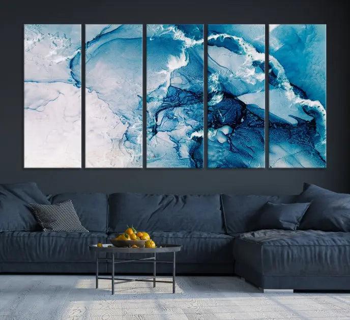 A set of Fluid Effect Wall Art Abstract Canvas prints, showcasing blue and white abstract designs on museum-quality canvas, is tastefully arranged on a dark wall.