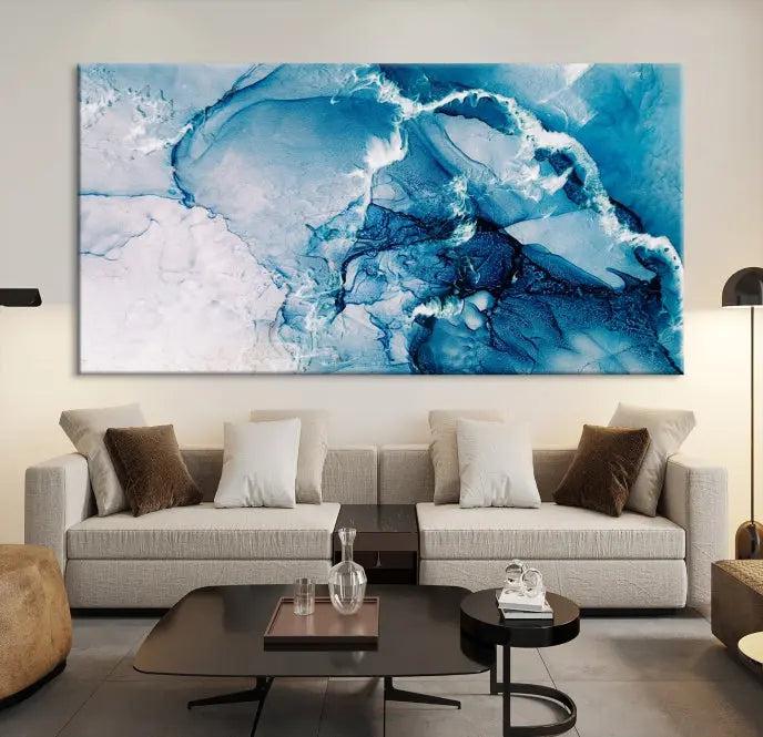 A set of Fluid Effect Wall Art Abstract Canvas prints, showcasing blue and white abstract designs on museum-quality canvas, is tastefully arranged on a dark wall.