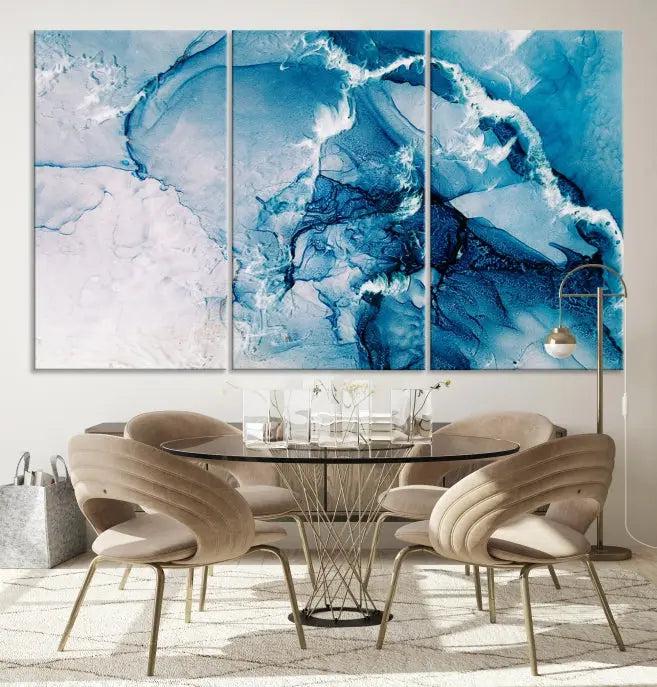 A set of Fluid Effect Wall Art Abstract Canvas prints, showcasing blue and white abstract designs on museum-quality canvas, is tastefully arranged on a dark wall.