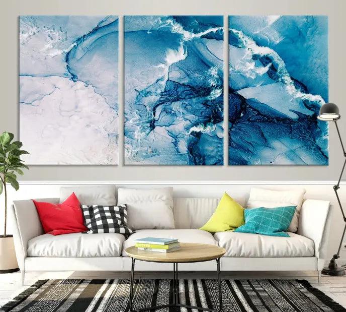 A set of Fluid Effect Wall Art Abstract Canvas prints, showcasing blue and white abstract designs on museum-quality canvas, is tastefully arranged on a dark wall.