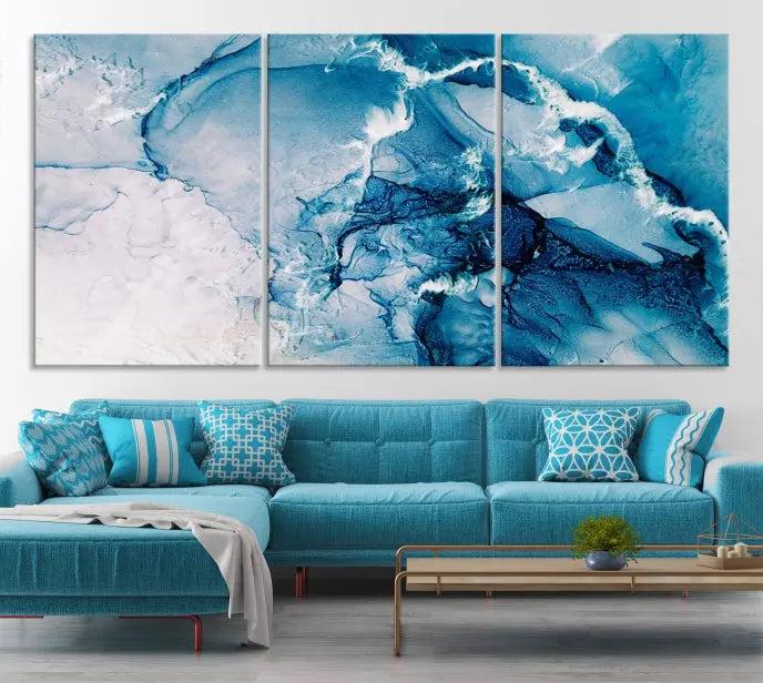 A set of Fluid Effect Wall Art Abstract Canvas prints, showcasing blue and white abstract designs on museum-quality canvas, is tastefully arranged on a dark wall.