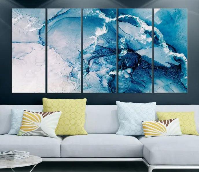 A set of Fluid Effect Wall Art Abstract Canvas prints, showcasing blue and white abstract designs on museum-quality canvas, is tastefully arranged on a dark wall.