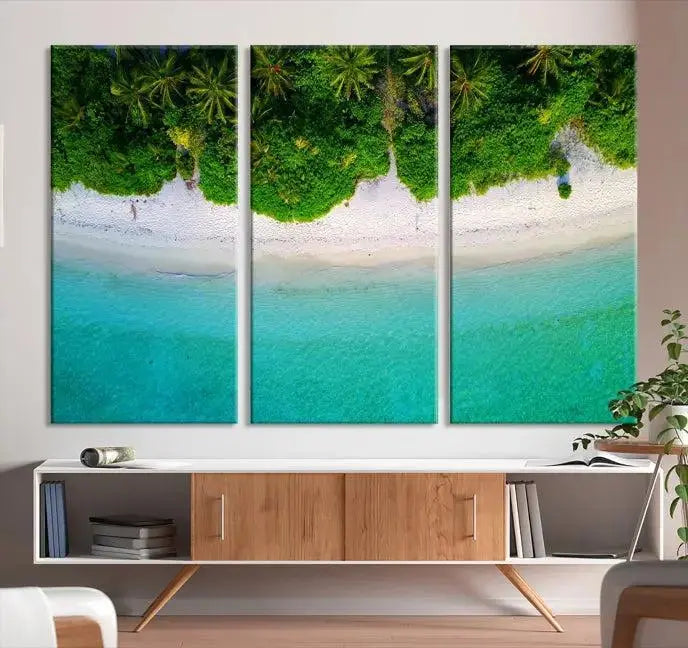 The Forest and Aerial Ocean Wall Art Canvas Print depicts a tropical beach scene, showcasing turquoise waters, white sand, and lush green trees. This triptych is gallery wrapped on museum-quality canvas and features a UV-protective coating to maintain its vibrant colors.