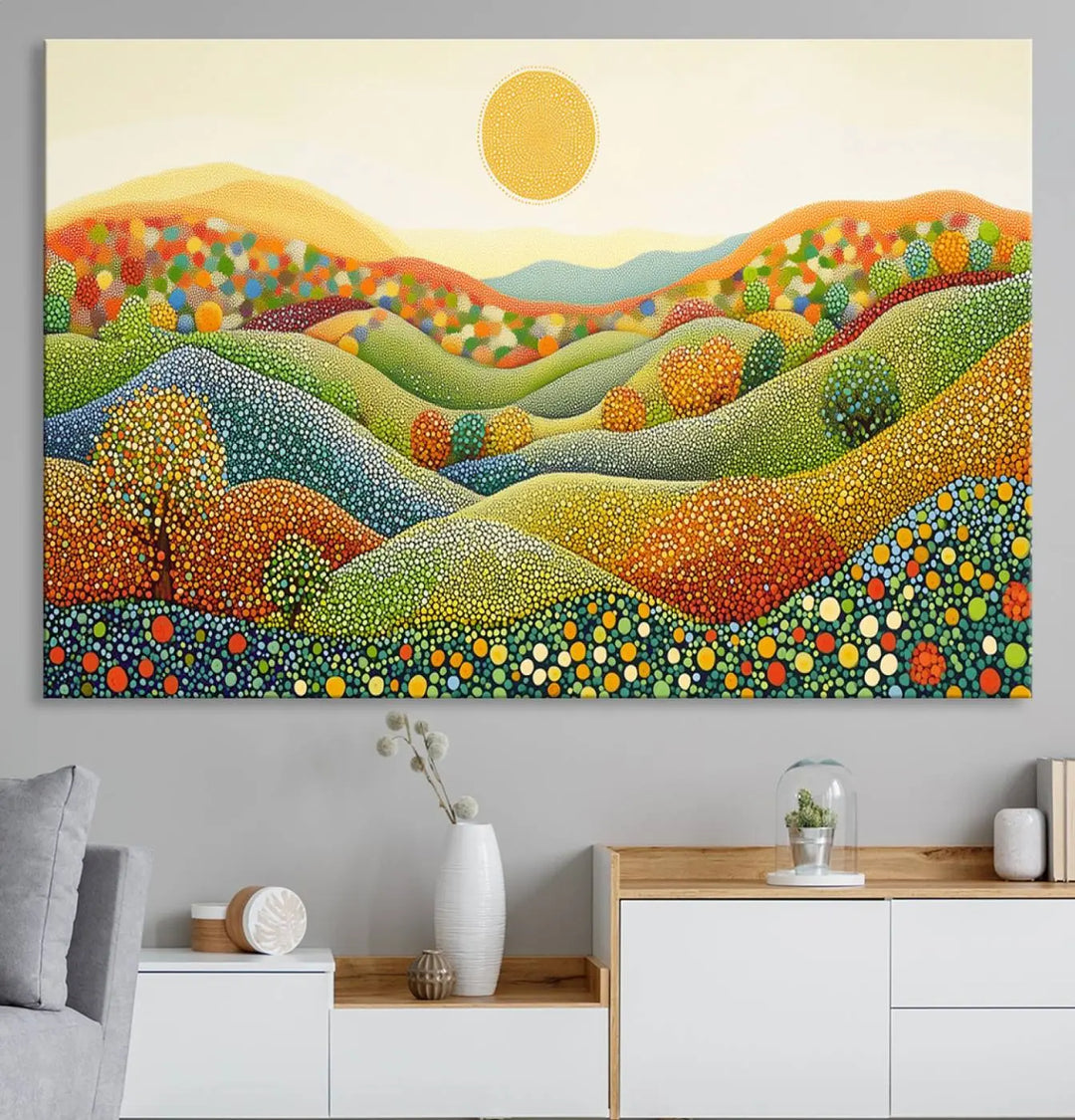 A framed Yayoi Kusama print featuring an abstract pointillism-inspired landscape of vibrant rolling hills and a sun.