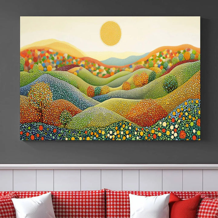 A framed Yayoi Kusama print featuring an abstract pointillism-inspired landscape of vibrant rolling hills and a sun.