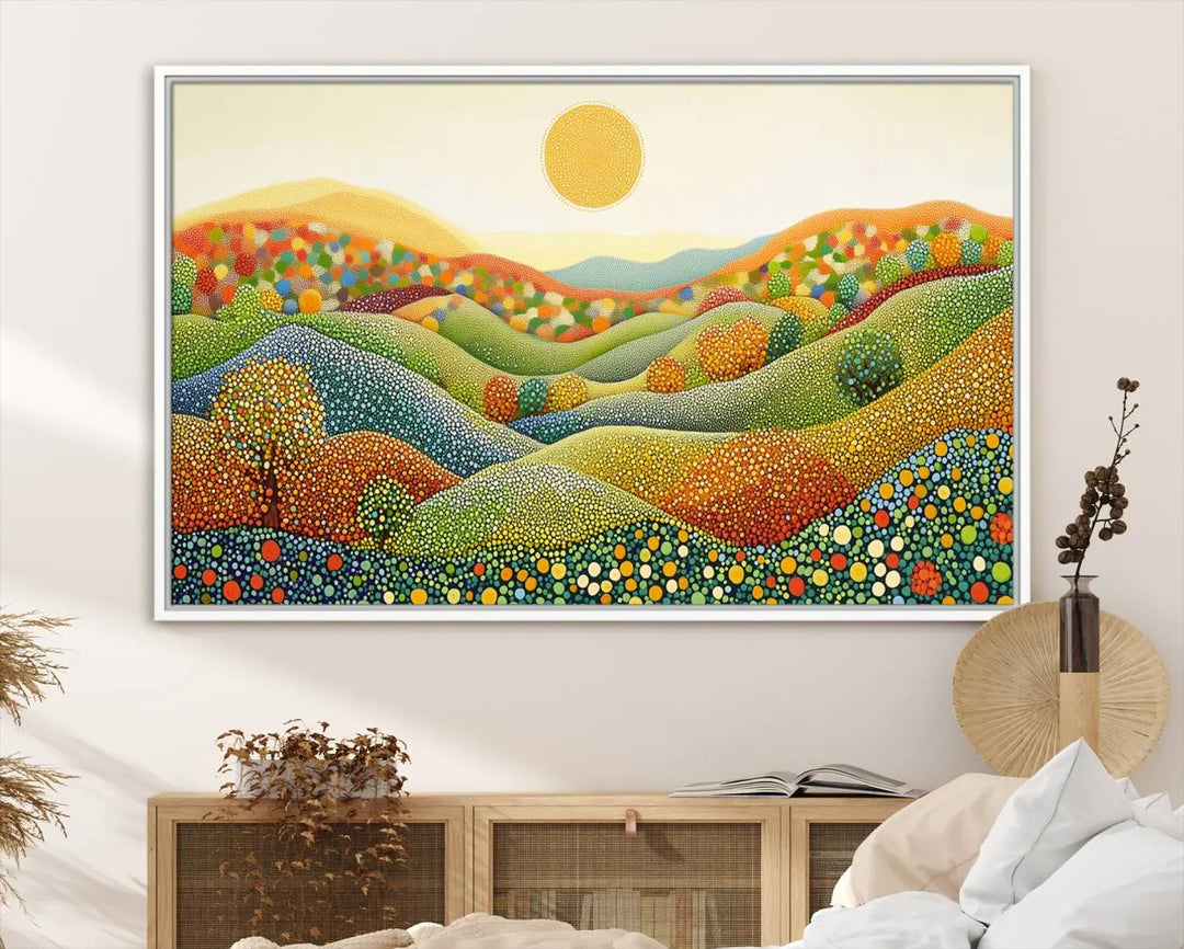 A framed Yayoi Kusama print featuring an abstract pointillism-inspired landscape of vibrant rolling hills and a sun.