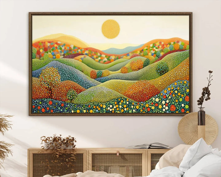 A framed Yayoi Kusama print featuring an abstract pointillism-inspired landscape of vibrant rolling hills and a sun.