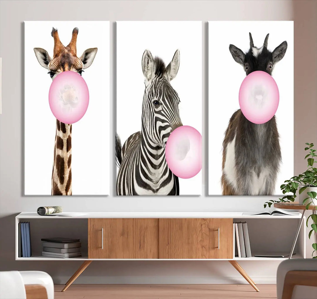 The "Funny Animals Canvas Wall Art Goat Zebra Giraffe Canvas Print" features a giraffe, zebra, and goat blowing pink bubblegum on museum-quality canvas, adding a playful touch to the space.