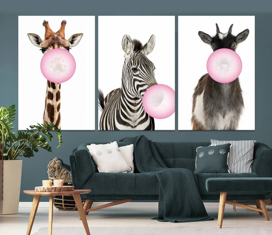 The "Funny Animals Canvas Wall Art Goat Zebra Giraffe Canvas Print" features a giraffe, zebra, and goat blowing pink bubblegum on museum-quality canvas, adding a playful touch to the space.