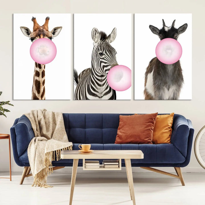 The "Funny Animals Canvas Wall Art Goat Zebra Giraffe Canvas Print" features a giraffe, zebra, and goat blowing pink bubblegum on museum-quality canvas, adding a playful touch to the space.