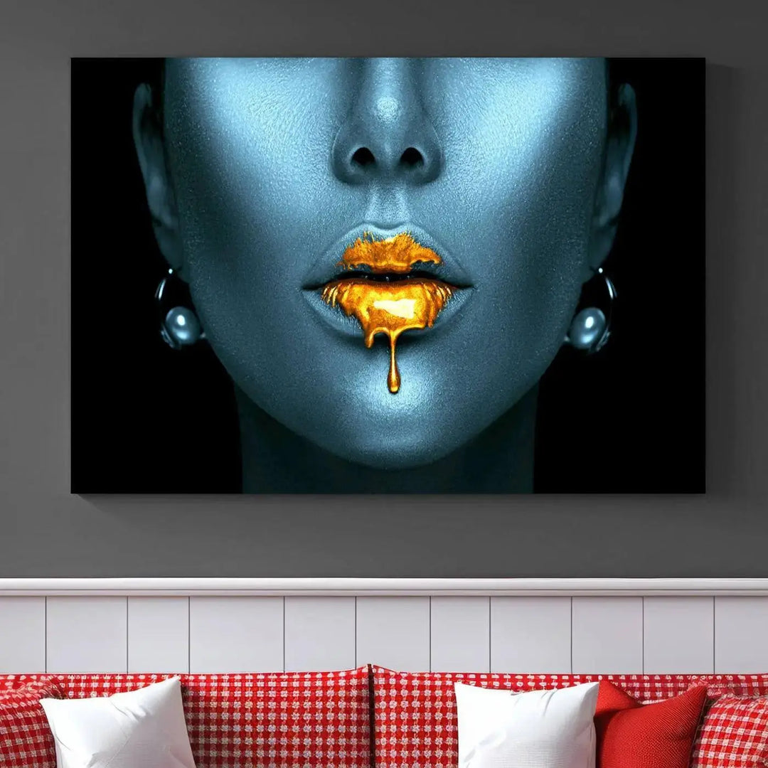 The Glitter Lips Wall Art Gold Lips Canvas Art Print in the contemporary living room showcases a blue-faced figure with glitter lips across three panels. The gallery-wrapped finish on high-quality polycotton canvas enhances the room's elegance.