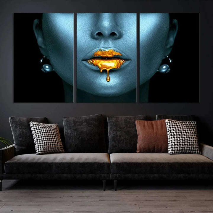 The Glitter Lips Wall Art Gold Lips Canvas Art Print in the contemporary living room showcases a blue-faced figure with glitter lips across three panels. The gallery-wrapped finish on high-quality polycotton canvas enhances the room's elegance.