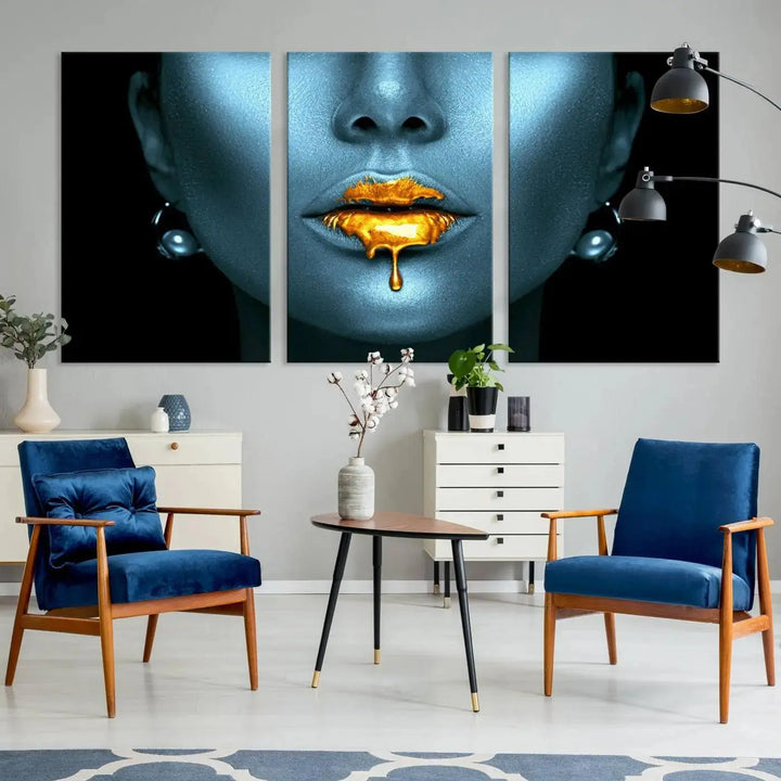 The Glitter Lips Wall Art Gold Lips Canvas Art Print in the contemporary living room showcases a blue-faced figure with glitter lips across three panels. The gallery-wrapped finish on high-quality polycotton canvas enhances the room's elegance.