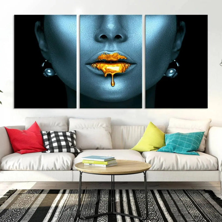 The Glitter Lips Wall Art Gold Lips Canvas Art Print in the contemporary living room showcases a blue-faced figure with glitter lips across three panels. The gallery-wrapped finish on high-quality polycotton canvas enhances the room's elegance.