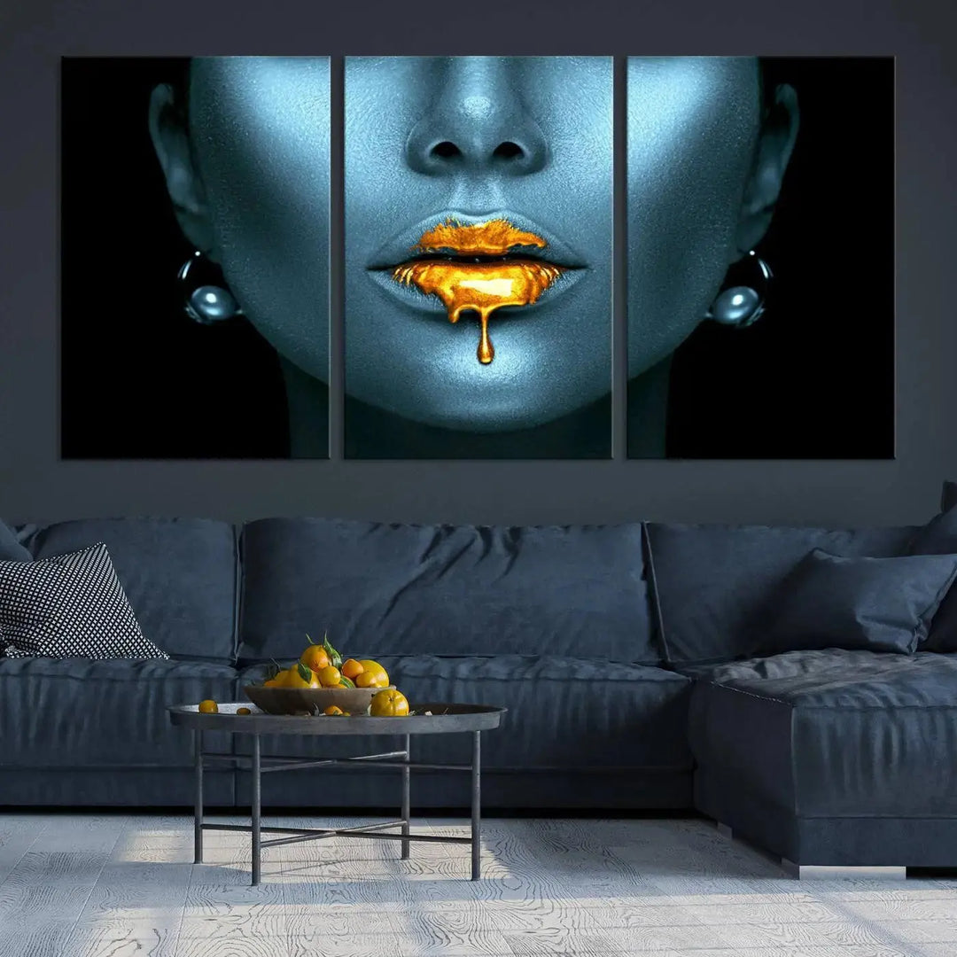 The Glitter Lips Wall Art Gold Lips Canvas Art Print in the contemporary living room showcases a blue-faced figure with glitter lips across three panels. The gallery-wrapped finish on high-quality polycotton canvas enhances the room's elegance.