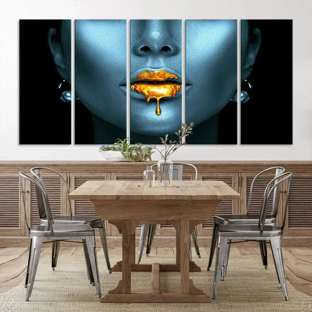 The Glitter Lips Wall Art Gold Lips Canvas Art Print in the contemporary living room showcases a blue-faced figure with glitter lips across three panels. The gallery-wrapped finish on high-quality polycotton canvas enhances the room's elegance.