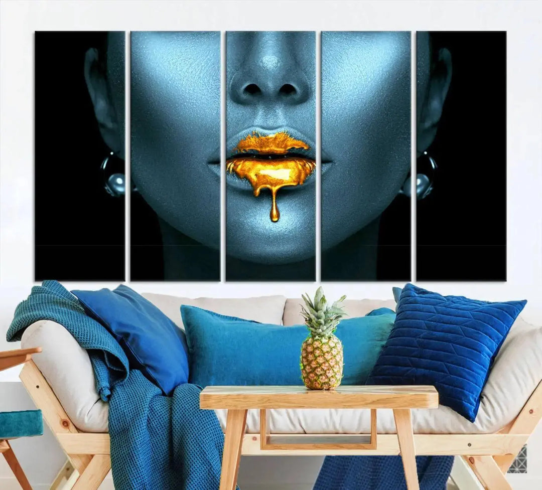 The Glitter Lips Wall Art Gold Lips Canvas Art Print in the contemporary living room showcases a blue-faced figure with glitter lips across three panels. The gallery-wrapped finish on high-quality polycotton canvas enhances the room's elegance.