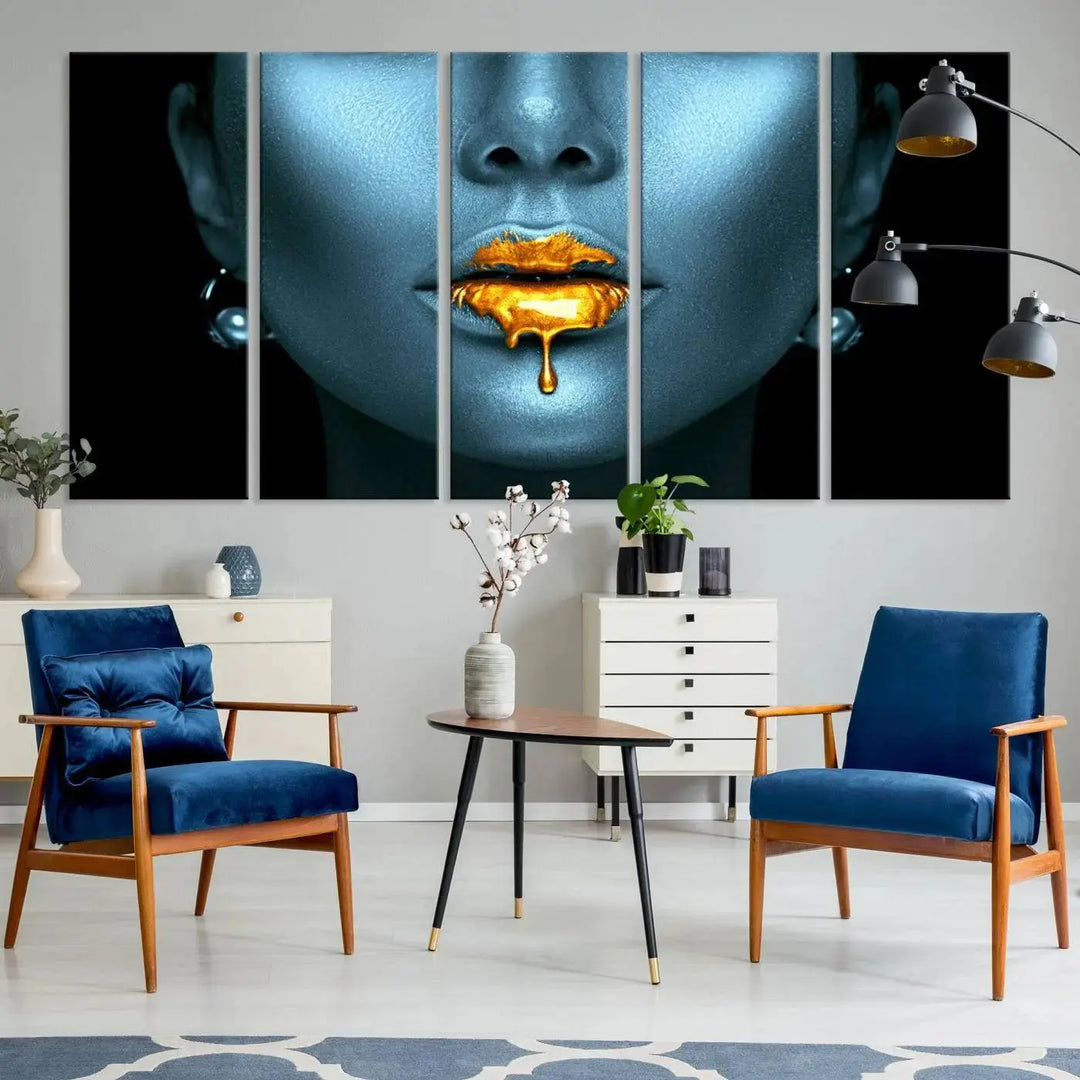 The Glitter Lips Wall Art Gold Lips Canvas Art Print in the contemporary living room showcases a blue-faced figure with glitter lips across three panels. The gallery-wrapped finish on high-quality polycotton canvas enhances the room's elegance.