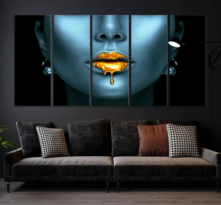 The Glitter Lips Wall Art Gold Lips Canvas Art Print in the contemporary living room showcases a blue-faced figure with glitter lips across three panels. The gallery-wrapped finish on high-quality polycotton canvas enhances the room's elegance.