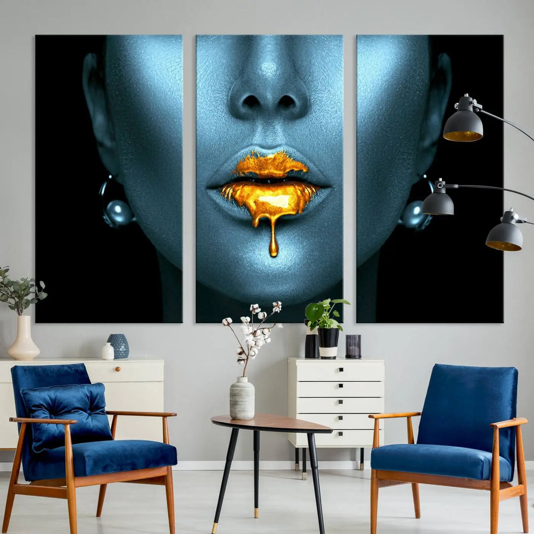 The Glitter Lips Wall Art Gold Lips Canvas Art Print in the contemporary living room showcases a blue-faced figure with glitter lips across three panels. The gallery-wrapped finish on high-quality polycotton canvas enhances the room's elegance.