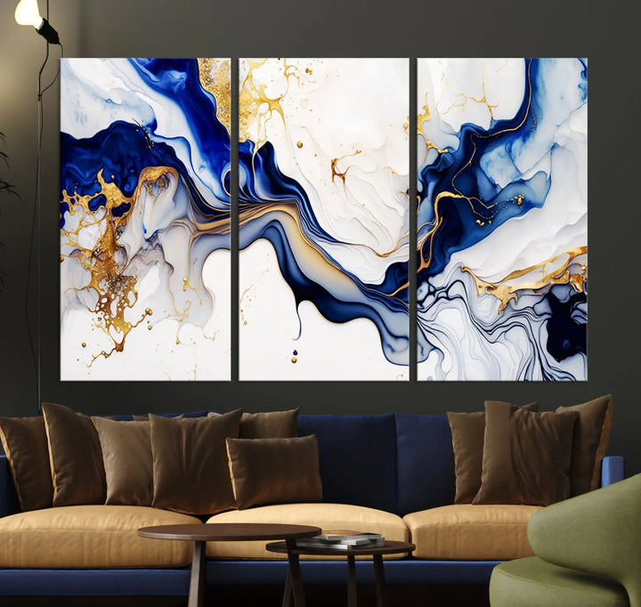 Enhance your modern home decor with the "Golden Cascades on Midnight Blue – Abstract Flowing Elegance" wall art canvas. This stunning piece features dynamic blue, gold, and white patterns. The triptych design comes framed and ready to hang, infusing any space with artistic expression.