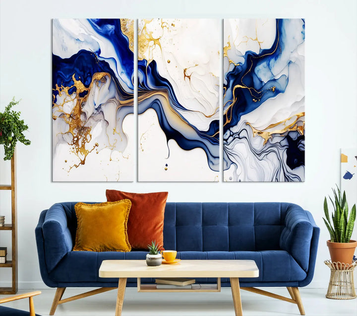 Enhance your modern home decor with the "Golden Cascades on Midnight Blue – Abstract Flowing Elegance" wall art canvas. This stunning piece features dynamic blue, gold, and white patterns. The triptych design comes framed and ready to hang, infusing any space with artistic expression.