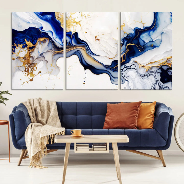 Enhance your modern home decor with the "Golden Cascades on Midnight Blue – Abstract Flowing Elegance" wall art canvas. This stunning piece features dynamic blue, gold, and white patterns. The triptych design comes framed and ready to hang, infusing any space with artistic expression.