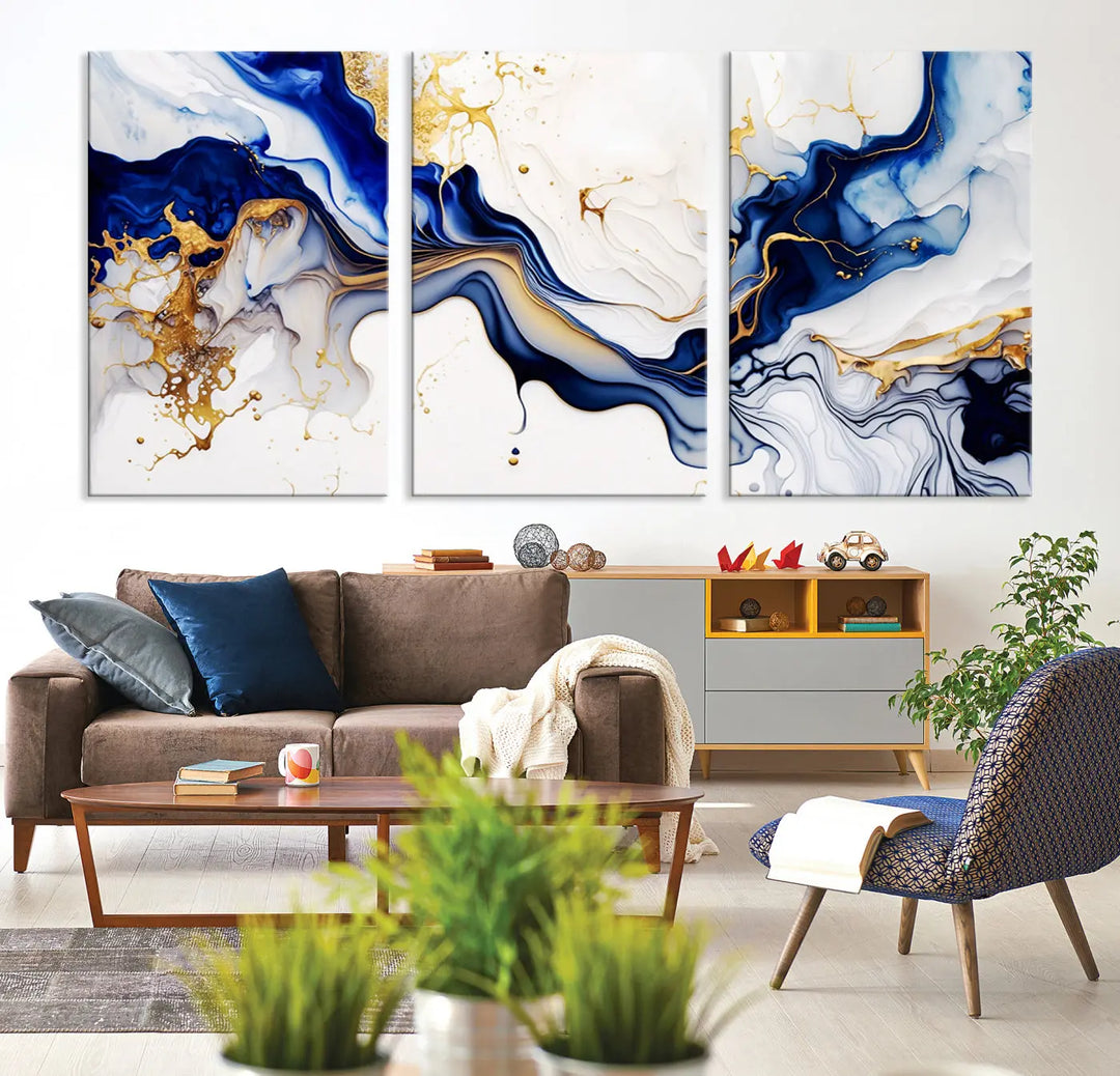 Enhance your modern home decor with the "Golden Cascades on Midnight Blue – Abstract Flowing Elegance" wall art canvas. This stunning piece features dynamic blue, gold, and white patterns. The triptych design comes framed and ready to hang, infusing any space with artistic expression.