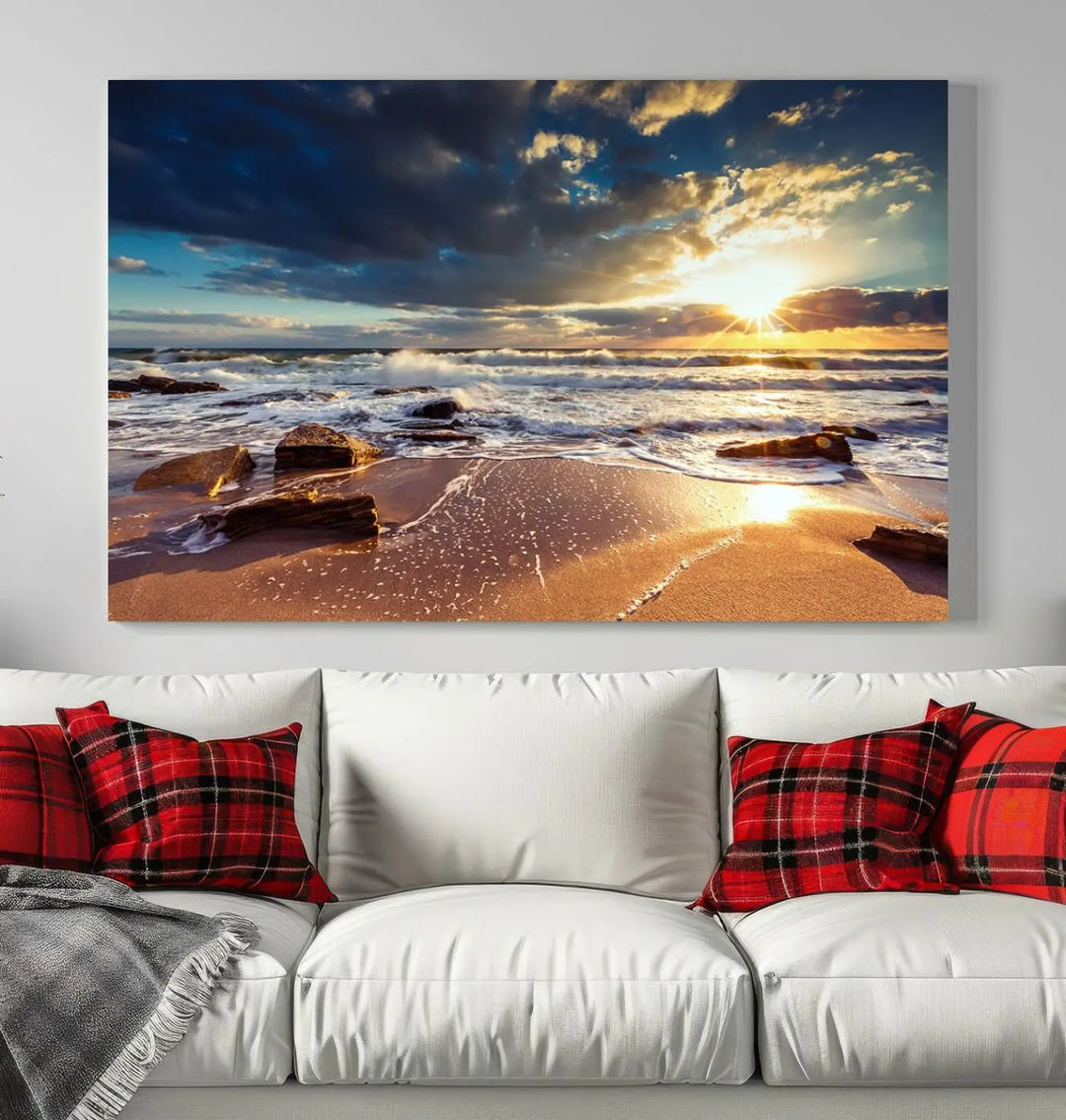 The cozy living room is enhanced by the Golden Hour Beach Sunset Canvas Triptych, featuring ocean waves and rocks.