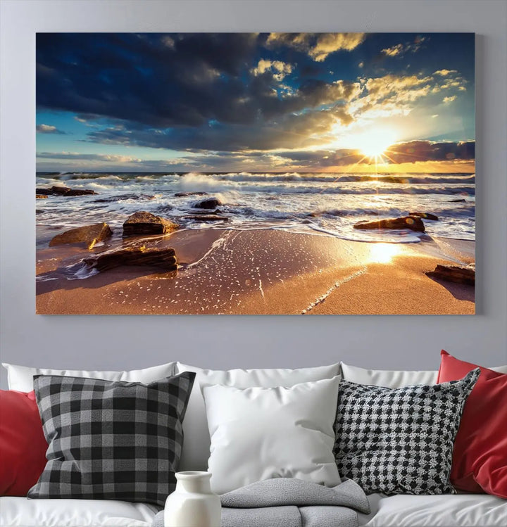 The cozy living room is enhanced by the Golden Hour Beach Sunset Canvas Triptych, featuring ocean waves and rocks.